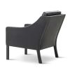 2207 Lænestol i sort læder, har en stramt defineret kontur og et blødt, komfortabelt indre