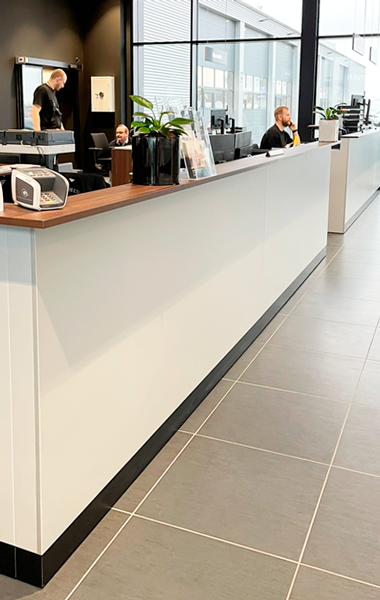 Lang skranke med trætop og sort bund