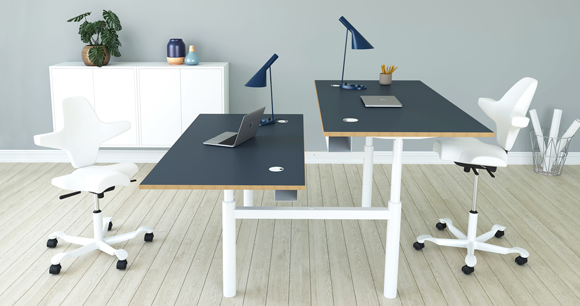 Lyst kontor med hæve-sænke borde i en dobbelt arbejdsplads 