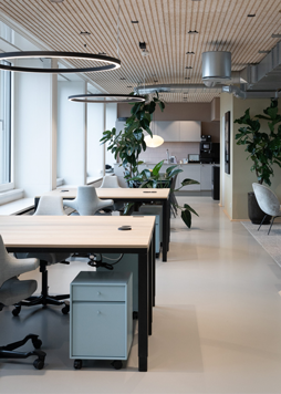 Aflangt lokale indrettet med lyse borde og blå detaljer