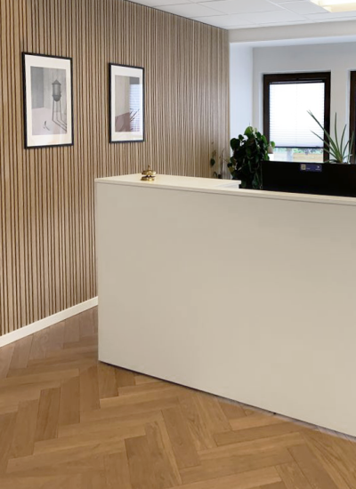 Hvid, minimalistisk skranke med lameller på væg