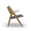 CH28 loungestol, sort læder. Design Hans J. Wegner, lænestol i træ, Carl Hansen & Søn. Få indretningsrådgivning til din virksomhed